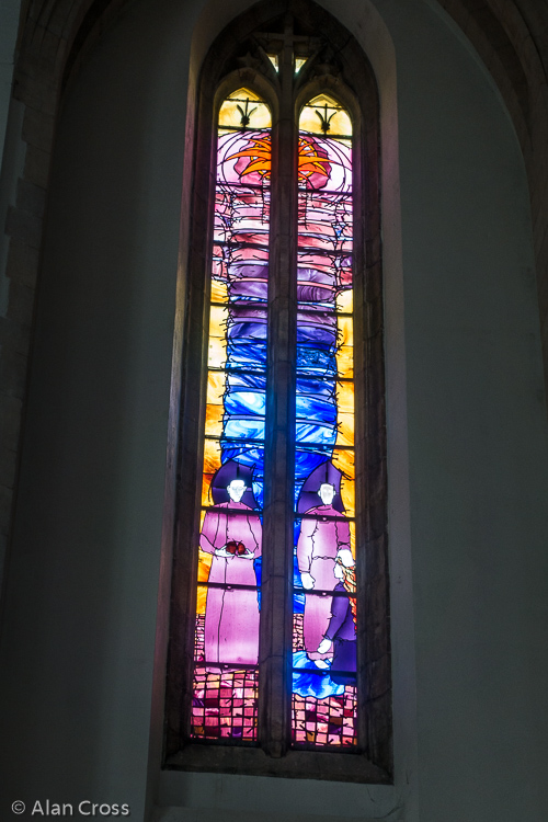 A window entitled 'Service', in the Chancel, given by Surrey County Council to commemorate its Centenary in 1989. Artist: Mark Angus.
