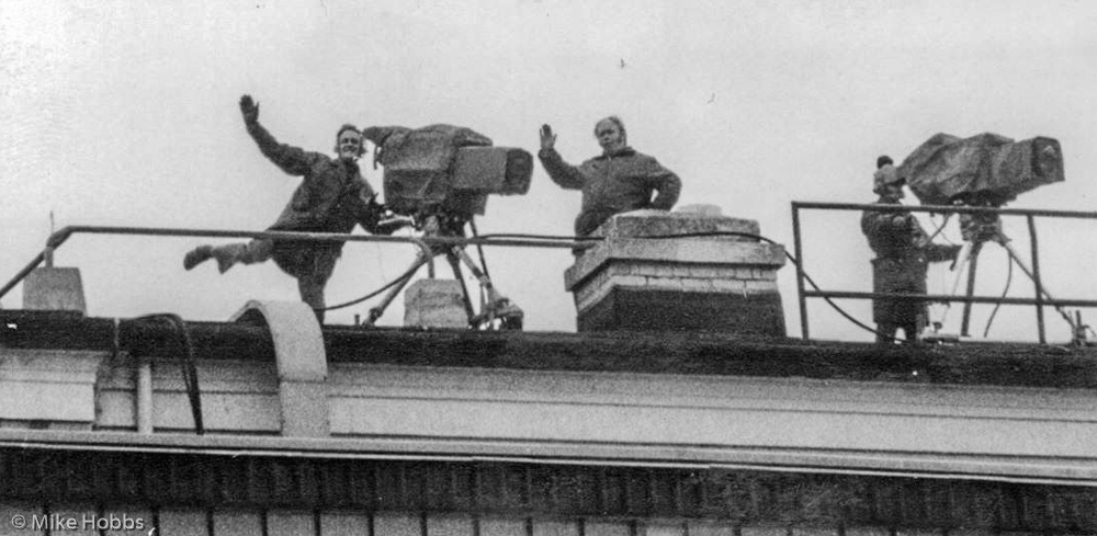 Three cameramen? skylarking  probably on a grandstand roof