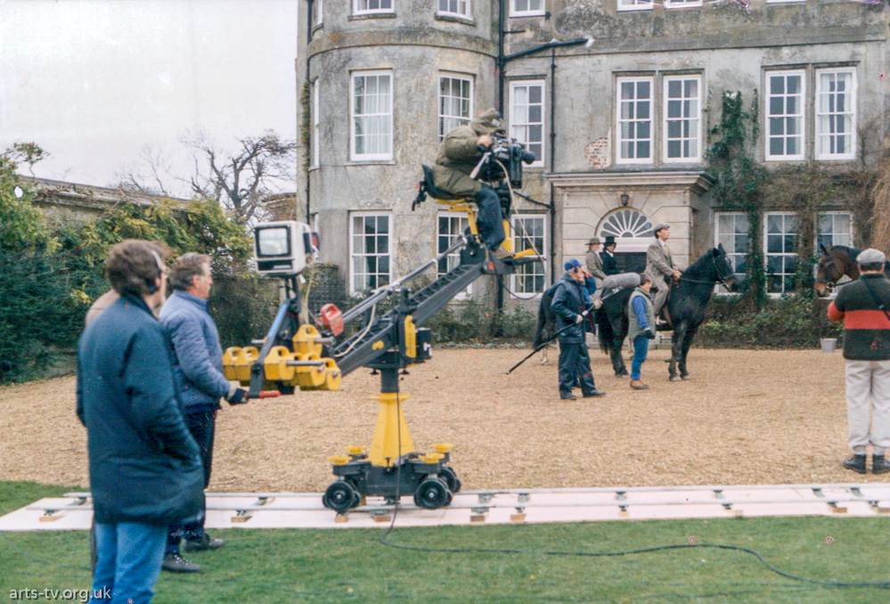 Mike Hobbs on camera crane outside stately house, program "Hannay", maybe Ron Burgess, grips; Tony Field, boom.  Actor Robert Powell on horse